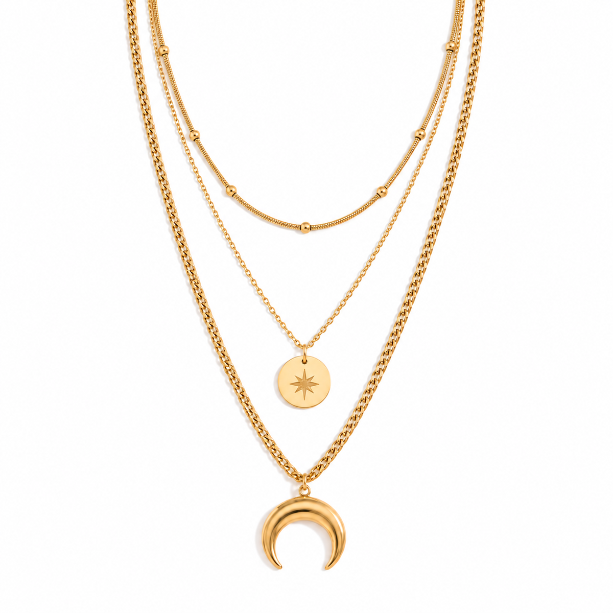 A layered gold necklace set featuring three distinct chains: a thick curb chain with a crescent moon pendant, a delicate chain with a round star disc pendant, and a fine beaded chain.